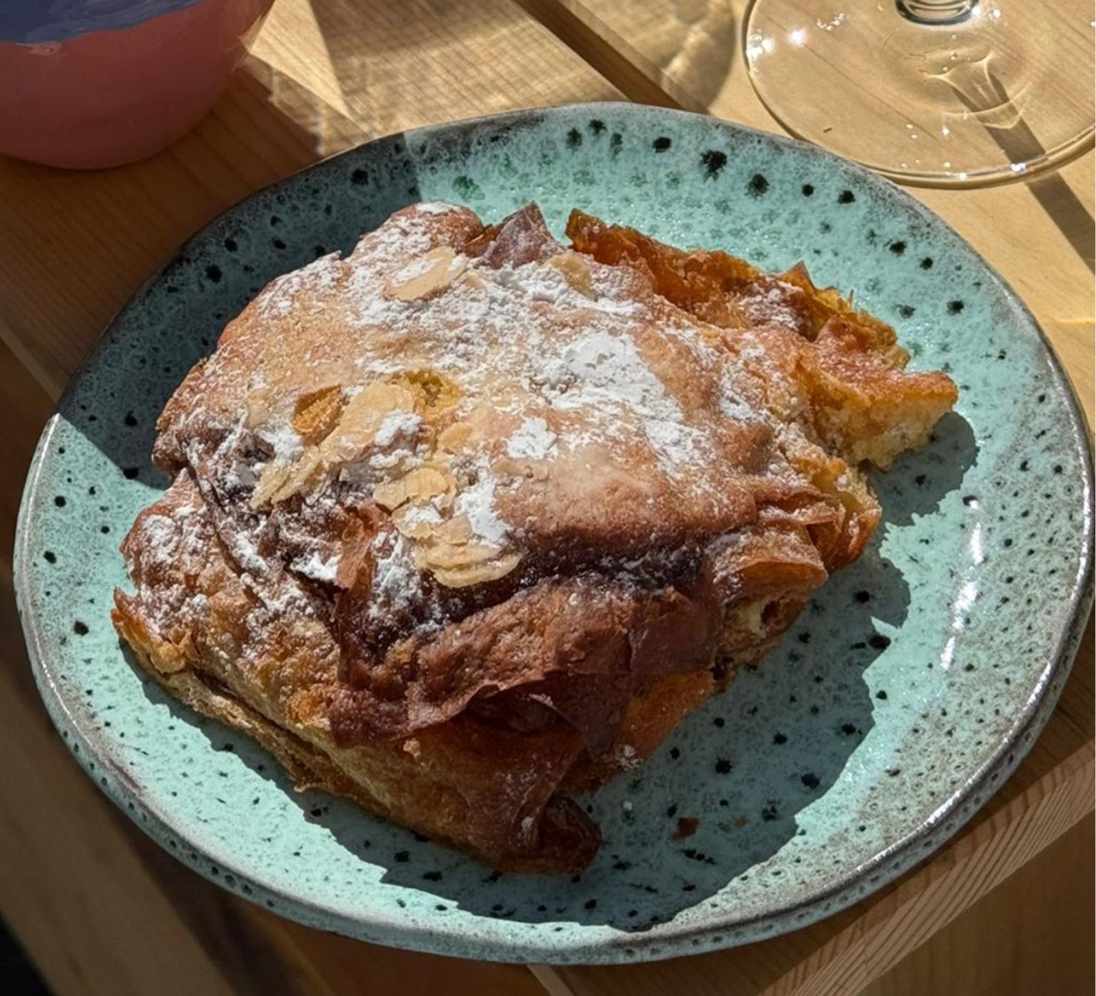 Croissant cu migdale pe o farfurie turcoaz